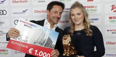 Christoph Bründl holding a Bründl shopping voucher. Next to him stands Valentina Höll with the Leonidas Lion for Rookie of the Year. 