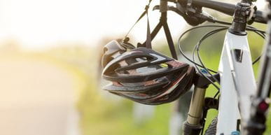 a helmet is hanging from the handlebar of a bycicle
