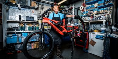 Ein Mitarbeiter mit einem Fahrrad in der Werkstatt 