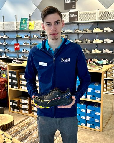 An employee of Bründl Sports showcases the latest Salomon shoes.