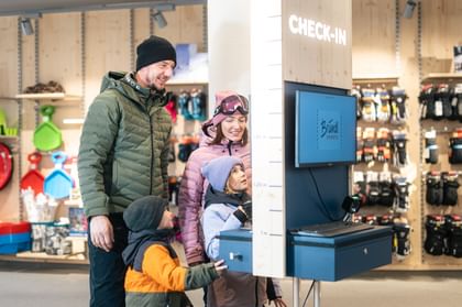 Eine Familie beim Bründl Sports Skiverleih Check-in Terminal 