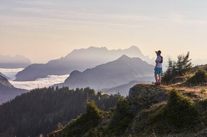 a trailrunner enjoys the view on the alpine mountain tops