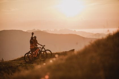 Radhfahrer auf den E-bikes vor einem Sonnenuntergang