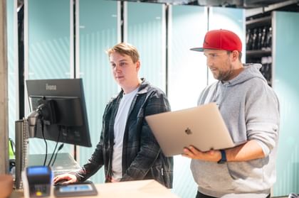Zwei IT Servicetechniker beim Überprüfen der Technik am Rent Check-in