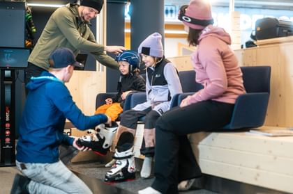 A family tries on ski boots for ski rental at Bründl Sports 