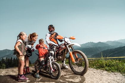 a motocrossrider and two kids