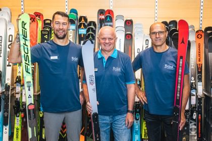 Brian Dettenbeck, Manfred Rogetzer and Hans Hofer in front of a ski wall.