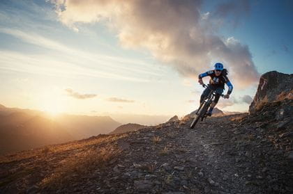 a mountainbiker drives through mountainous terrain 