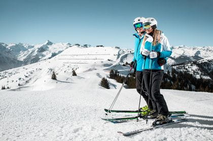 two skiers are standing on a slope