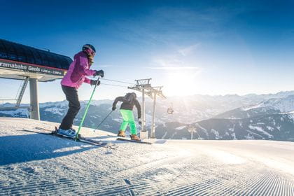Zwei Skifahrer bei Sonnenaufgang in Fügen