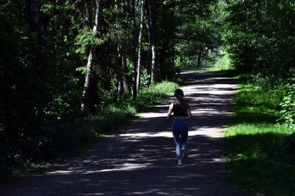 A women runs through a shadowy avenue