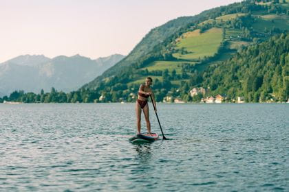 Frau fährt mit einem Stand Up Paddle durch das Wasser