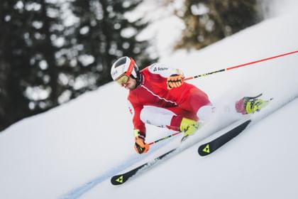Stefan Brennsteiner fährt in voller Rennmontur mit hoher Geschwindigkeit eine eisige Piste hinunter.
