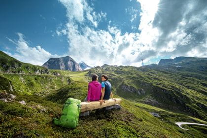 two hikers are sitting on a bench at Kitzsteinhorn