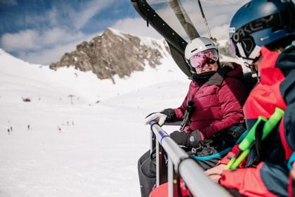 Zwei Skifahrer sitzen am Sessellift