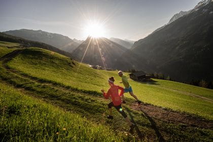 two people are sprinting along a mountain path