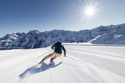 BOA Skiier A skier wearing BOA ski boots on a freshly groomed slope in the sunshine.
