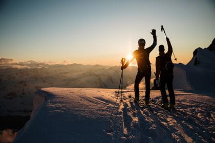 Zwei Skitourengeher am Gipfel bei Sonnenuntergang im National Park Hohe Tauern