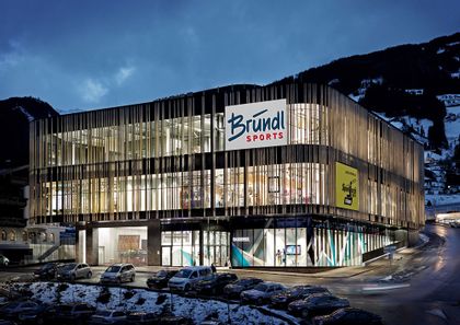 Der Bründl Sports Shop direkt an der Spieljochbahn hell erleuchtet in der Winterdämmerung