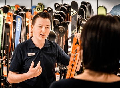 Bründl Sports employee explains everything about an Atomic ski to a consumer