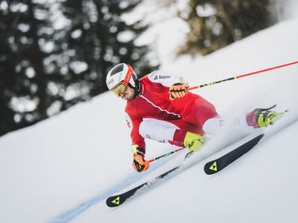 Stefan Brennsteiner fährt in voller Rennmontur mit hoher Geschwindigkeit eine eisige Piste hinunter.