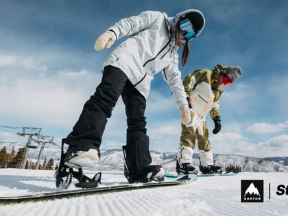 Zwei Snowboarder beim Einsteigen in die Burton Step On Bindung
