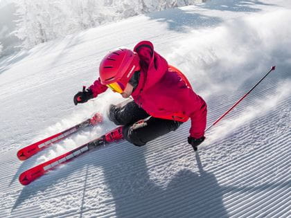 A skier carving down a slope with the new Atomic Redster Revoshock