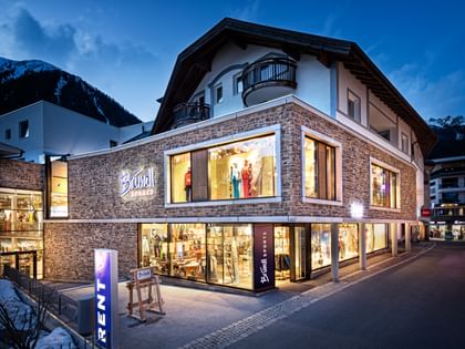 Bründl Sports Ischgl Zentrum well-lit shopwindow - winter evening view <br/>