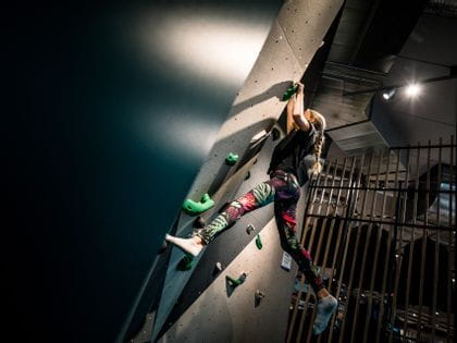 Young girl who is climbing at the Bründl Sports wall for bouldering in their shop in Saalfelden