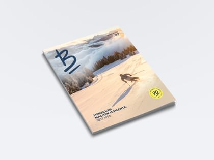 Das Bründl Sports Magazin zeigt einen Skifahrer auf einer verschneiten Skipiste vor einer Berglandschaft. Auf dem Cover stehen unter anderem „Menschen machen Momente. Seit 1956.“, „Bründl Sports #7“ und „70 Bründl Sports seit 1956“.