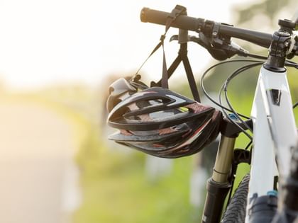 a helmet is hanging from the handlebar of a bycicle