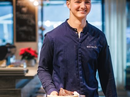 Lehrling beim Servieren der Speisen