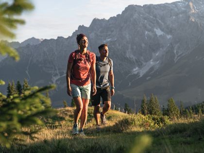 Ein Paar genießt den Sonnenaufgang während ihrer Wanderung auf dem Berg