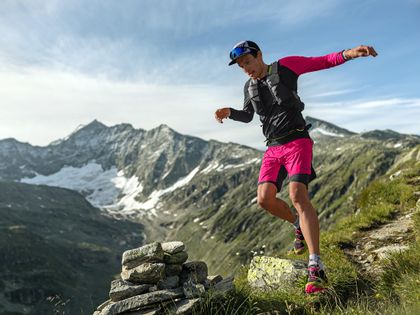 A trailrunner running throught the mountains. He is dressed with shoes and clothes from Dynafit. 
