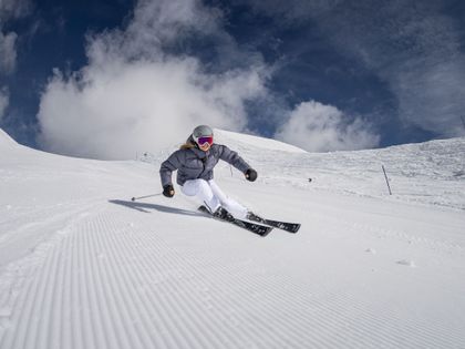Skifahrerin carvt auf der Piste mit dem neuen Pistenski Real Joy SLR von Head