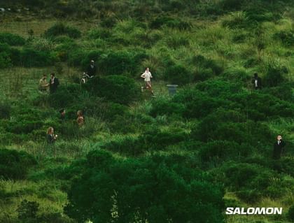 Several people move through a lush green landscape, including a runner, pedestrians, and individuals with a bicycle or smartphone.