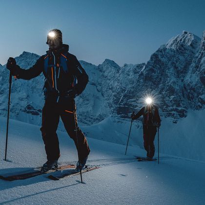 A couple ski touring at night. 