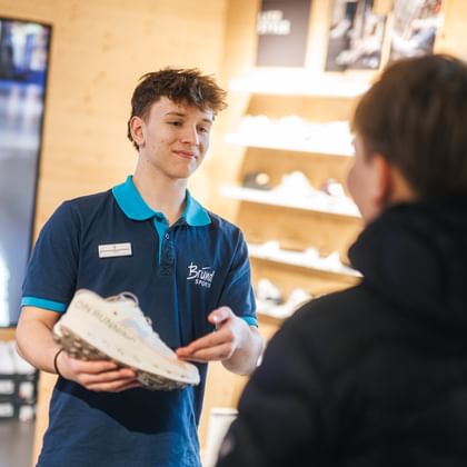 Lehrling beim Verkauf von Schuhen