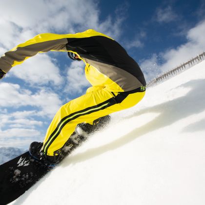 Snowboarder fährt an einem schönen Tag abseits von der Piste