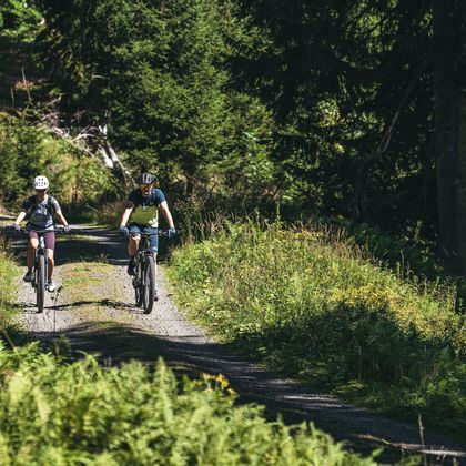 A happy couple enjoys a summer bike ride in the mountains.