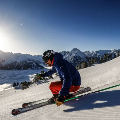 ein Skifahrer auf der Piste mit starker Schräglage