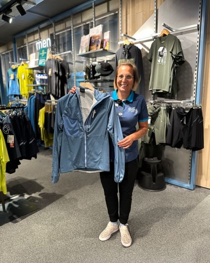 Bründl Sports employee shows the new PeakPerformance jacket in blue.