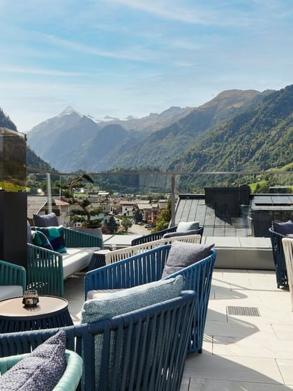 The stylish rooftop terrace with cozy lounge furniture offers a breathtaking panoramic view of the surrounding Alps and the idyllic valley.