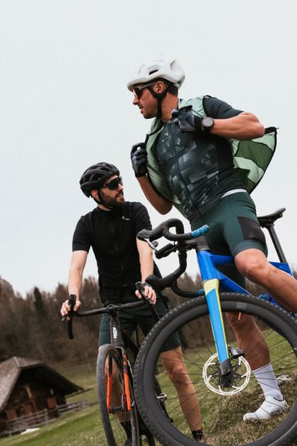 Two gravel bikers in Löffler apparel standing with their bikes outdoors